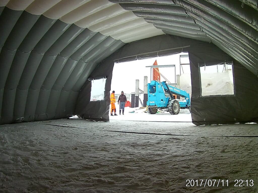 View from inside the Njordair storage tent towards a telehandler at the entrance