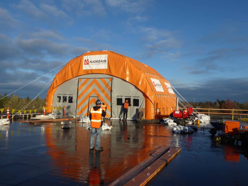 Orange Njordair Constant Air tent enclosing roof coating works on a commercial building in Oregon