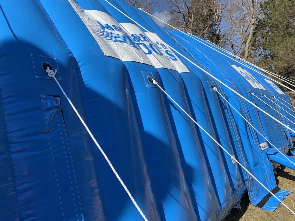 Custom-branded blue Njordair tent panels secured with guy ropes