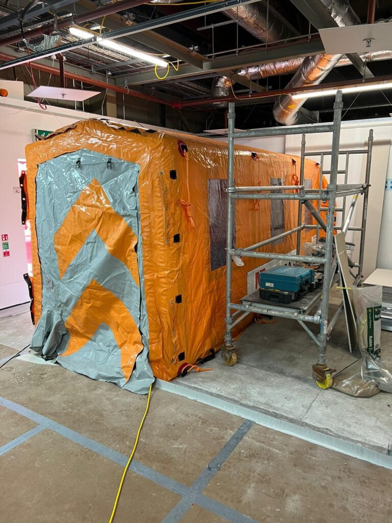 Compact Njordair dust containment enclosure set up beside scaffolding indoors