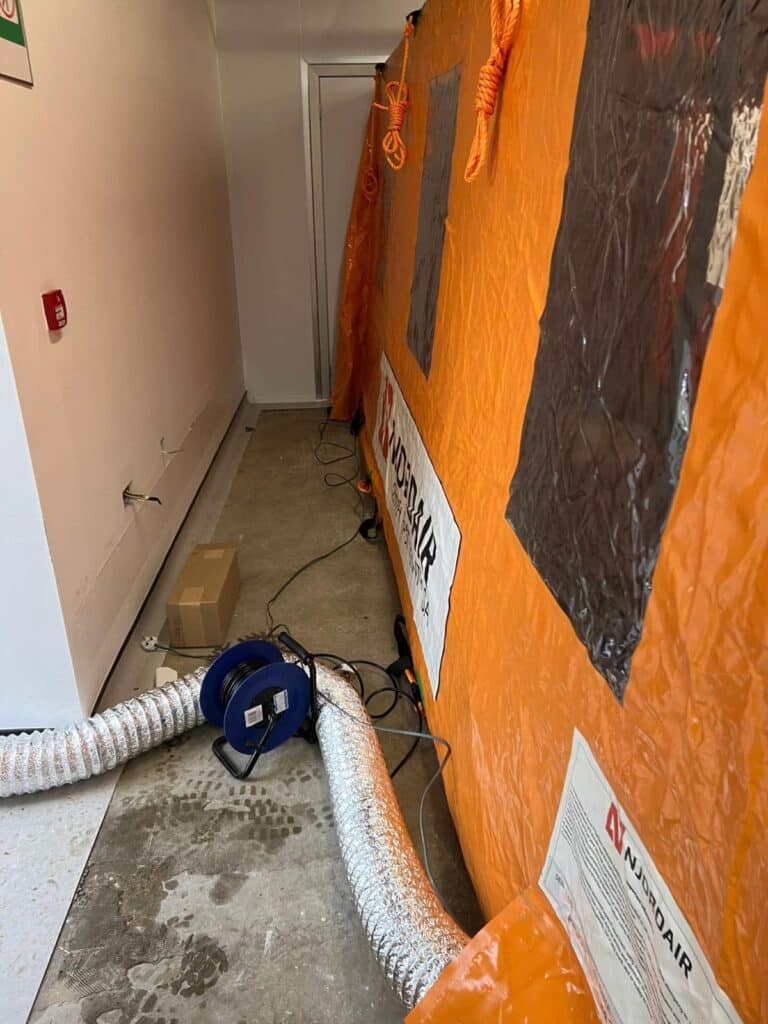 Extraction ducting connected to the Njordair containment tent in the facility corridor