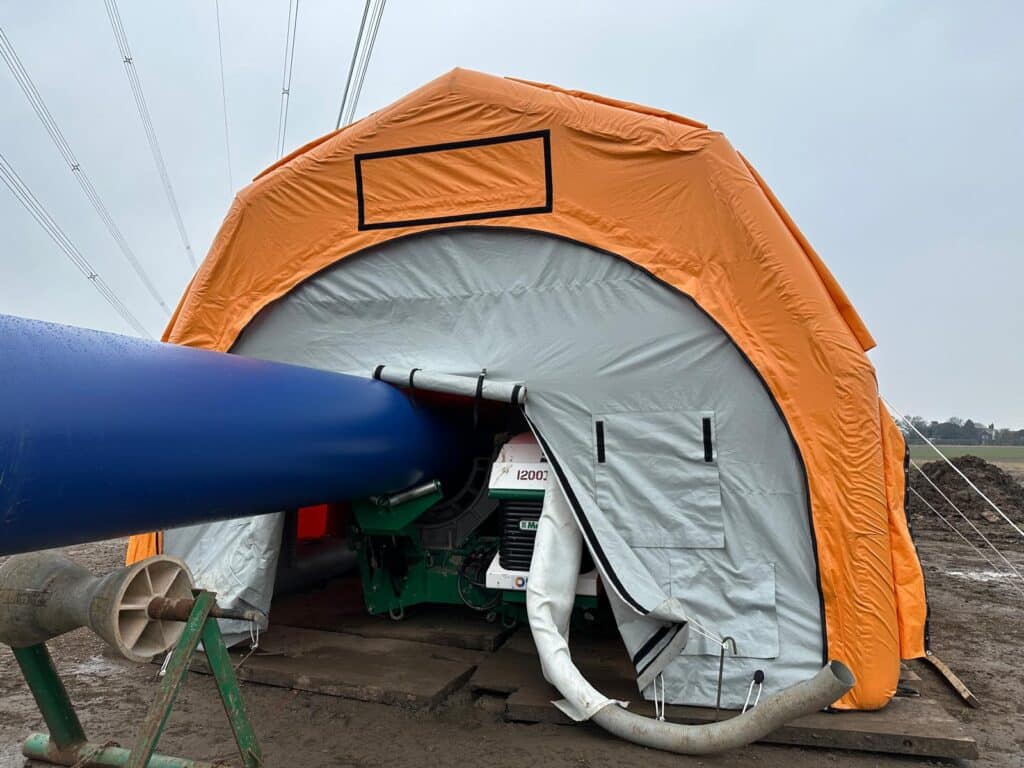Pipe section passing through the entrance of the Njordair welding tent